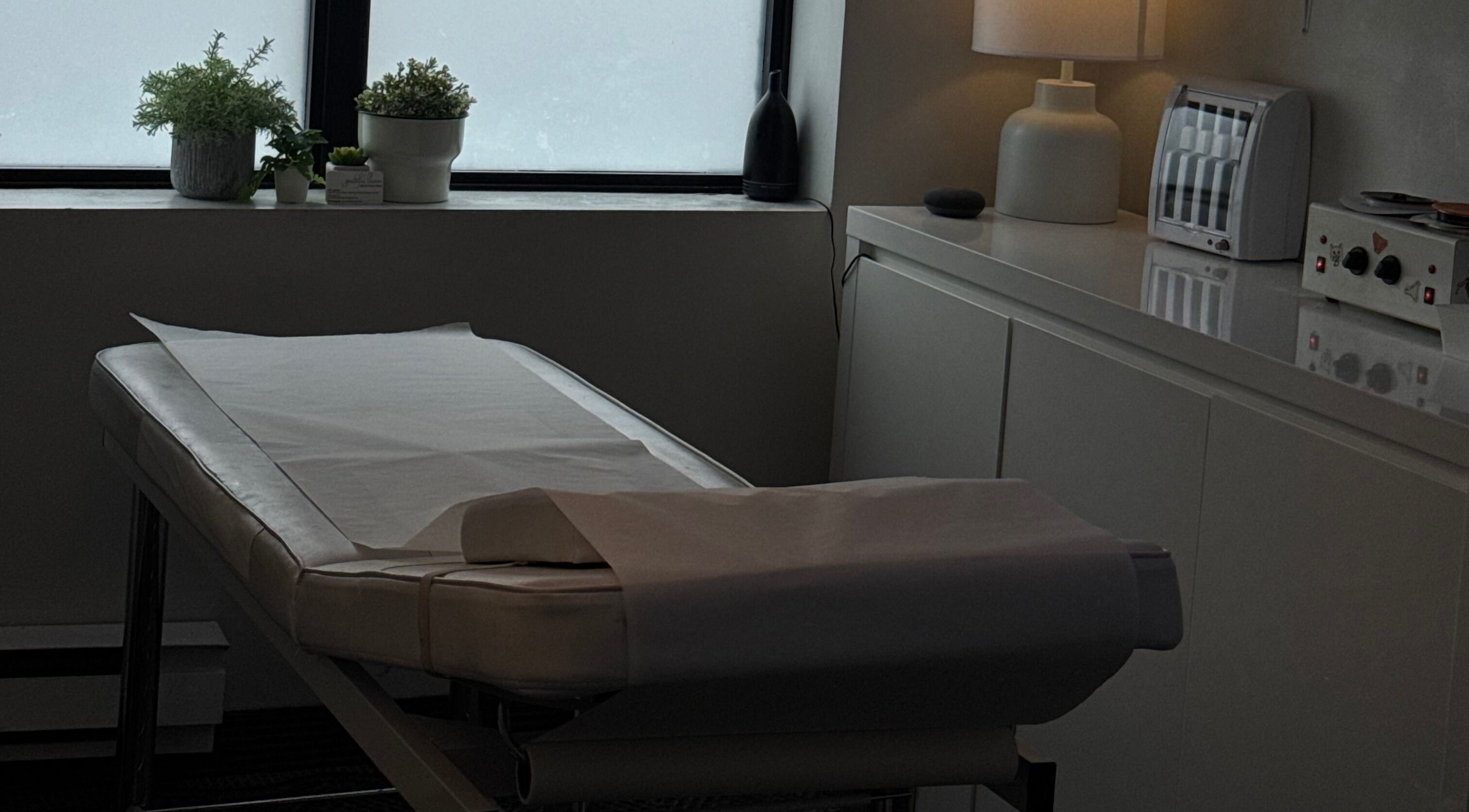 Massage table at The Brandy Alexander, Whitby, Ontario, CA, adorned with plants for a calming ambiance.
