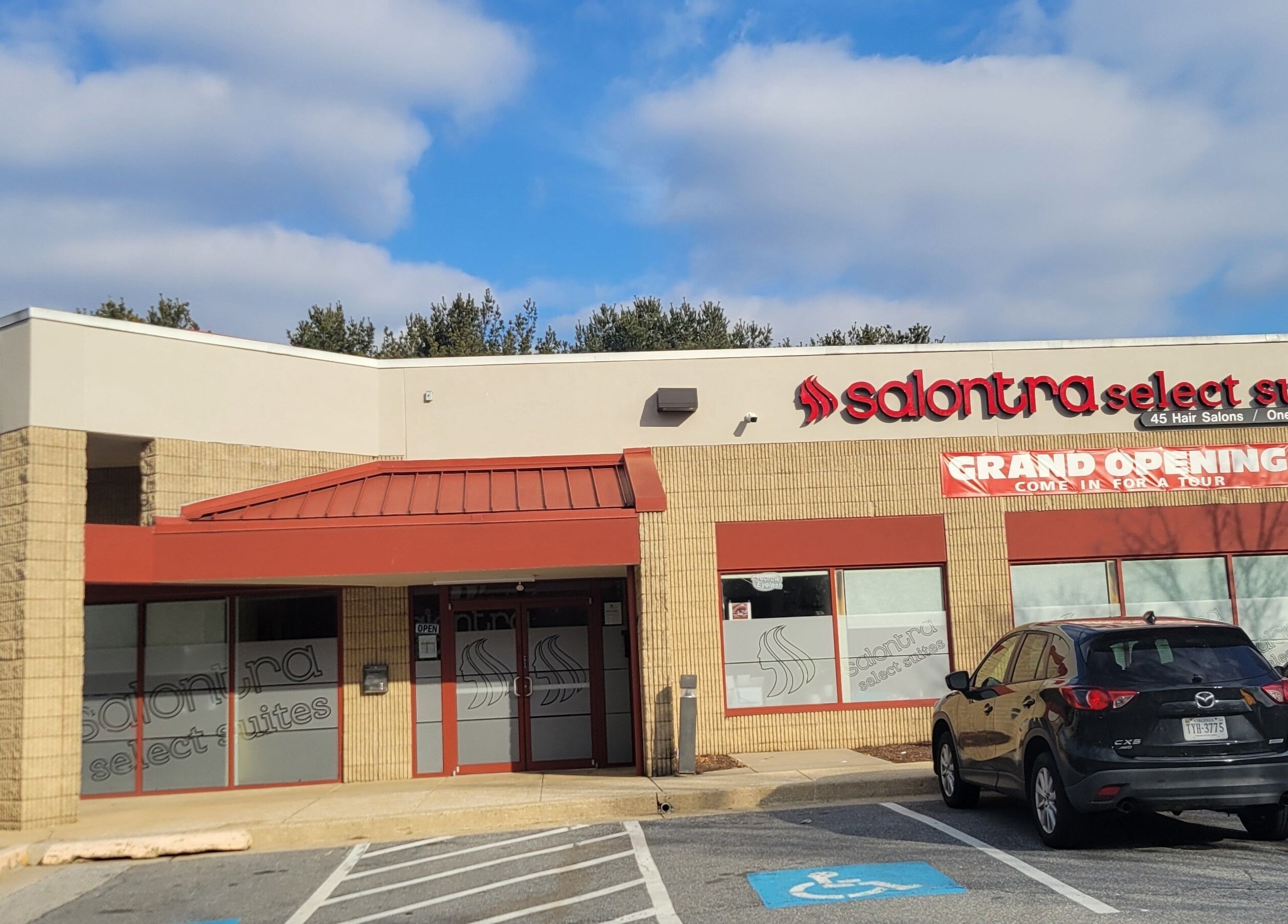 Fachada moderna de AHS SALON MD en Columbia, MD, PR, destacando entrada y anuncio de apertura.