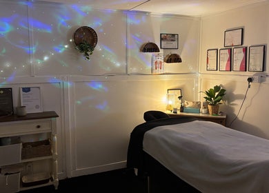 Tranquil massage room at Shell Mckee Wellness, Northwich, England, GB with decorative lighting and wall art.