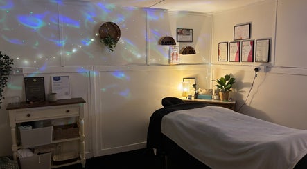 Tranquil massage room at Shell Mckee Wellness, Northwich, England, GB with decorative lighting and wall art.