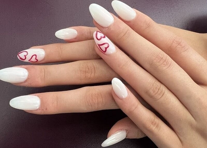 Stylish nail art with white polish and heart details at Angeline Nails & Beauty Worcester Park, Worcester Park, England, GB.