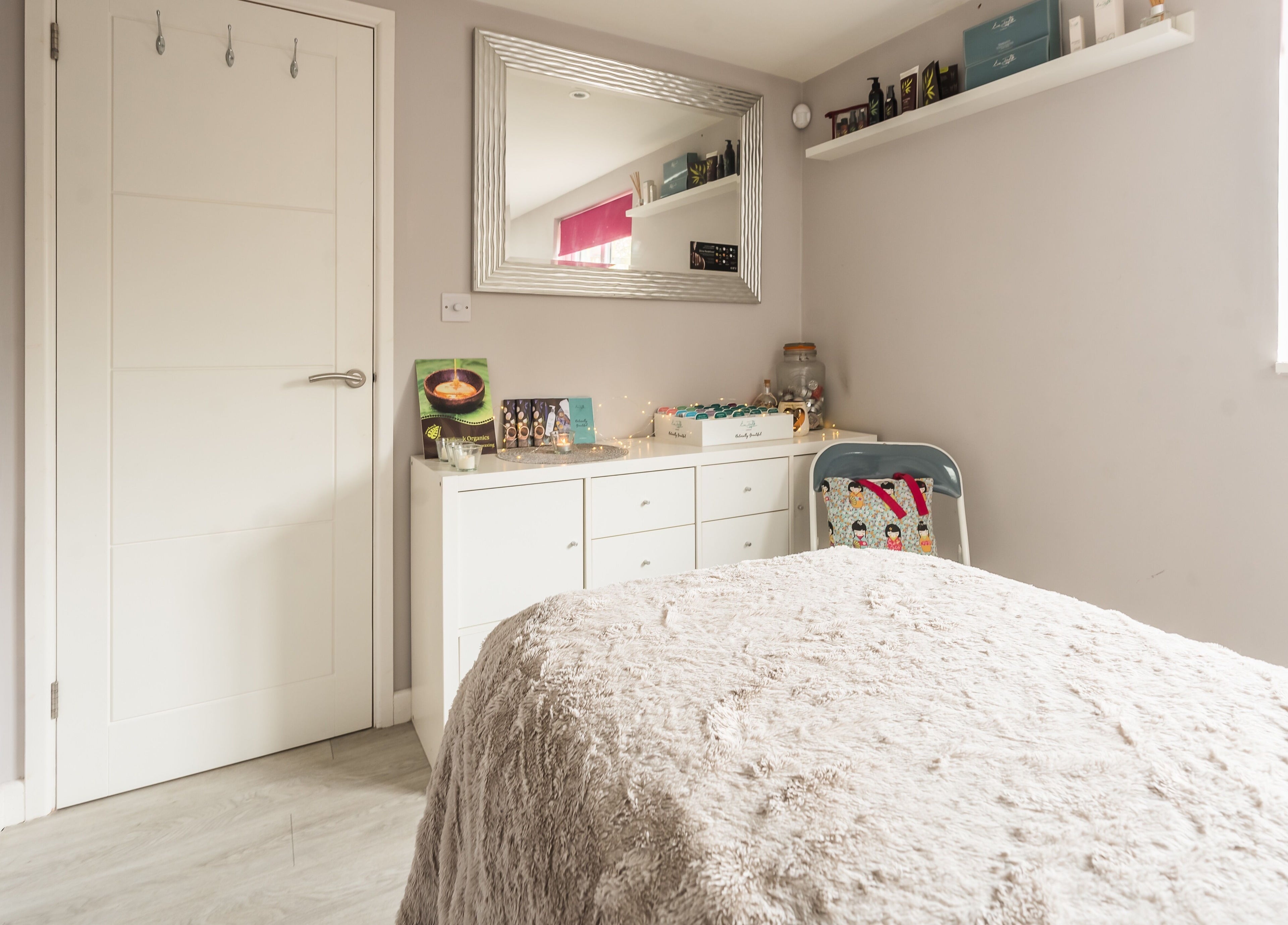 Relaxing treatment room at Fuchsia Beauty, Bristol, England, GB featuring a cozy bed and elegant decor.