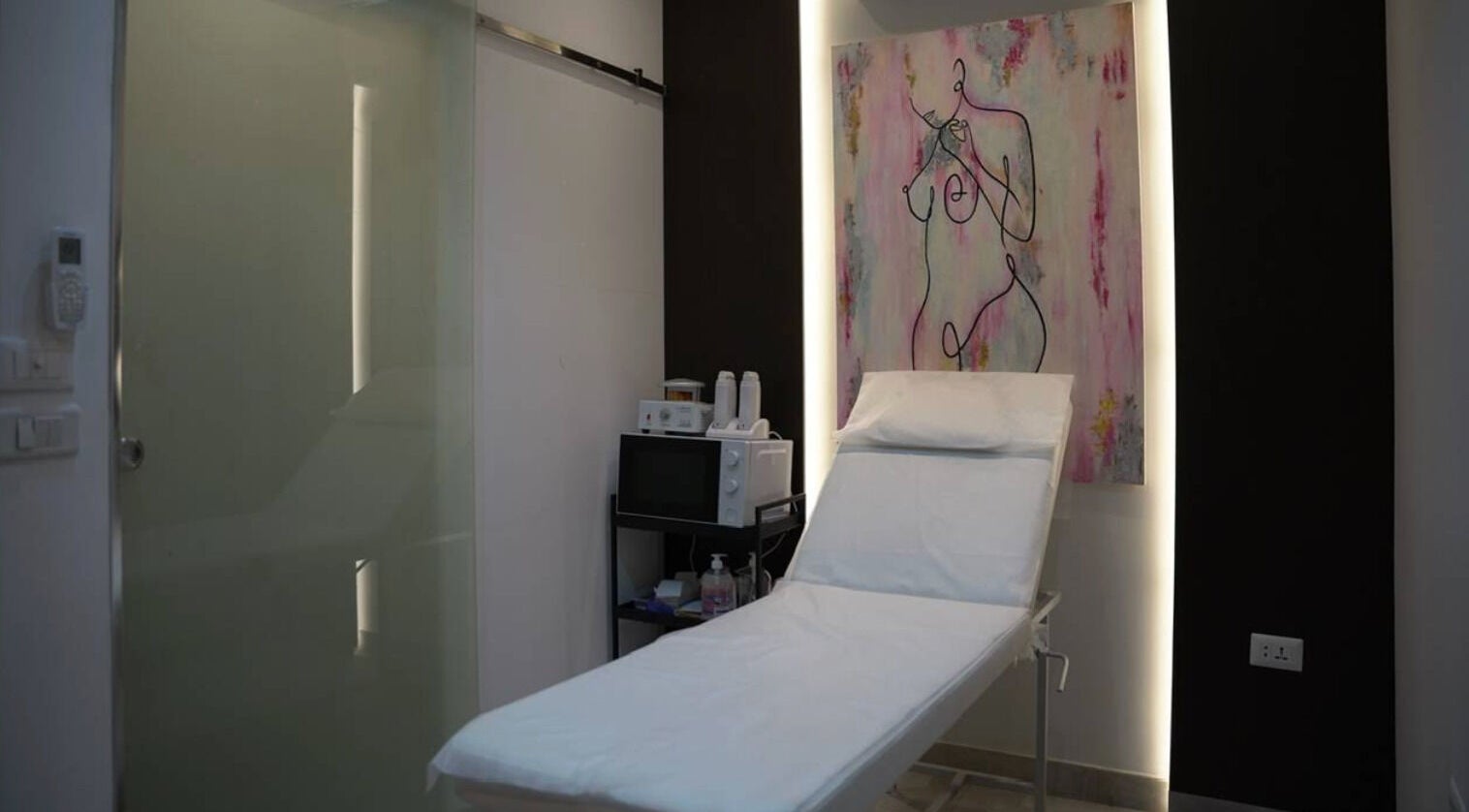 Modern treatment room at Gloss'd Beauty Bar, Amman, with sleek decor and stylish artwork.