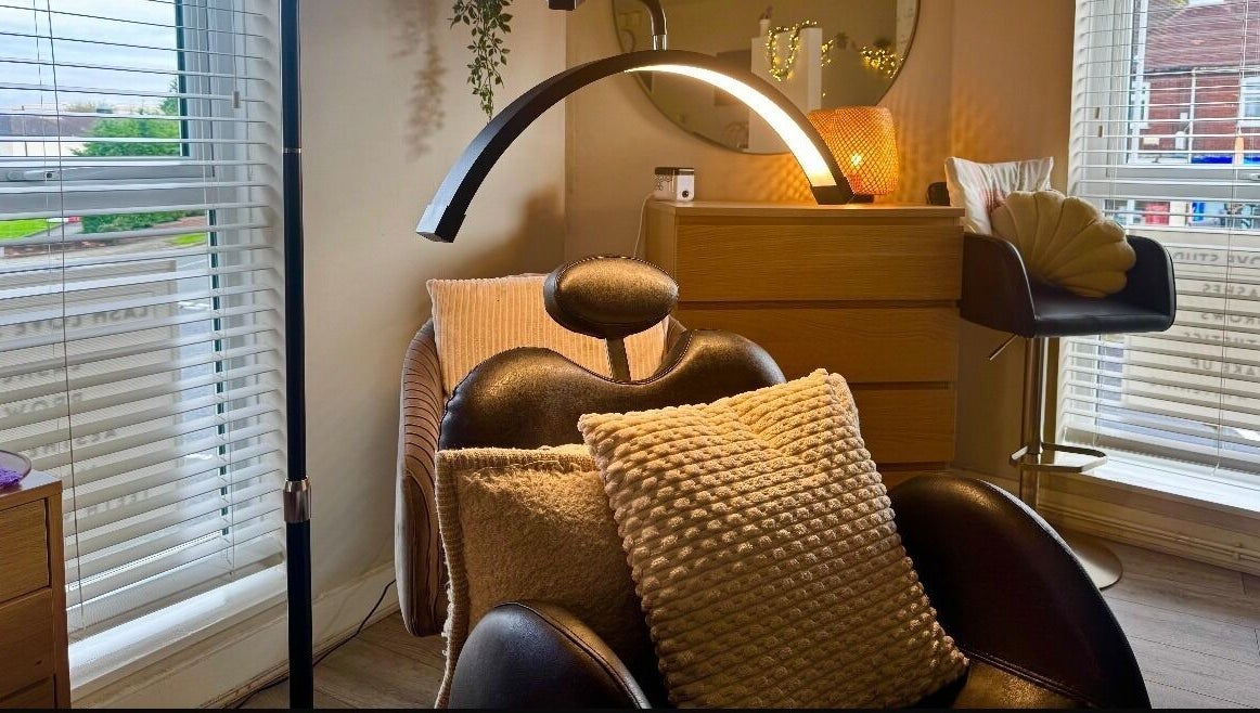 Relaxing treatment room at Lash Love Faye in Birkenhead, England, GB, featuring a plush chair and warm lighting.