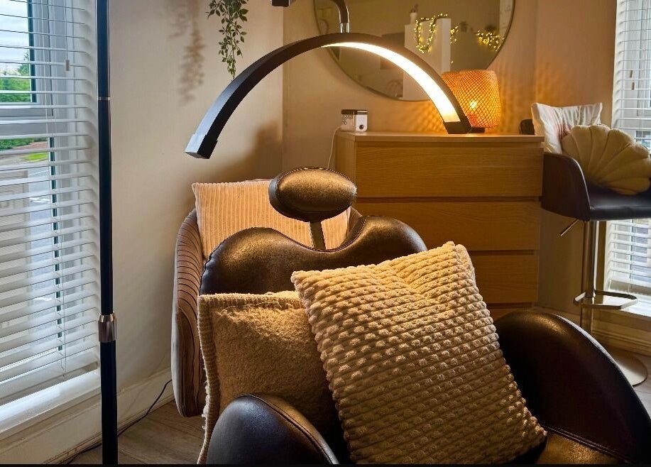 Relaxing treatment room at Lash Love Faye in Birkenhead, England, GB, featuring a plush chair and warm lighting.