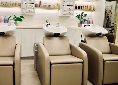 Elegant wash stations at Nado Salon, Sharjah, AE, featuring plush seats and chic decor.