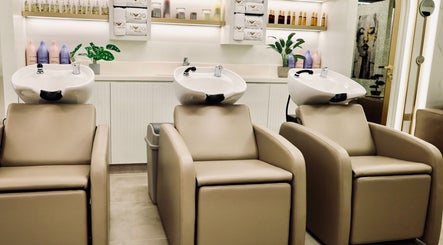 Elegant wash stations at Nado Salon, Sharjah, AE, featuring plush seats and chic decor.