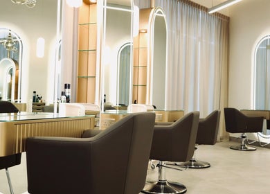 Elegant salon interior at Nado Salon, Sharjah, AE with mirrored stations and stylish seating.