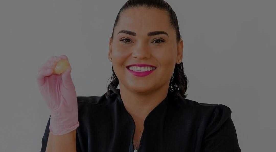 Smiling beauty therapist at Bonaire Beauty By X in Kralendijk, Bonaire, BQ holding a skincare product.