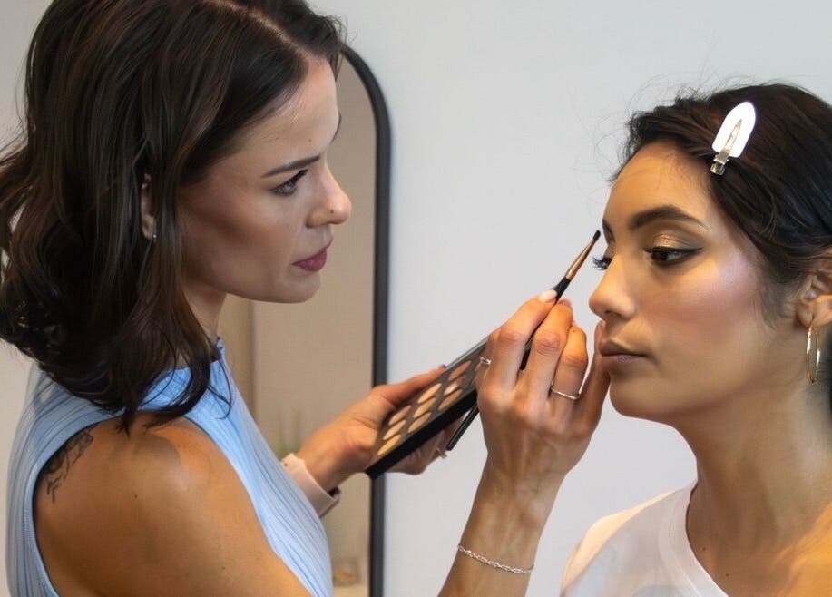 Makeup artist at Angelic Aesthetics in Cape Town, Western Cape, ZA applies eye makeup to a client.