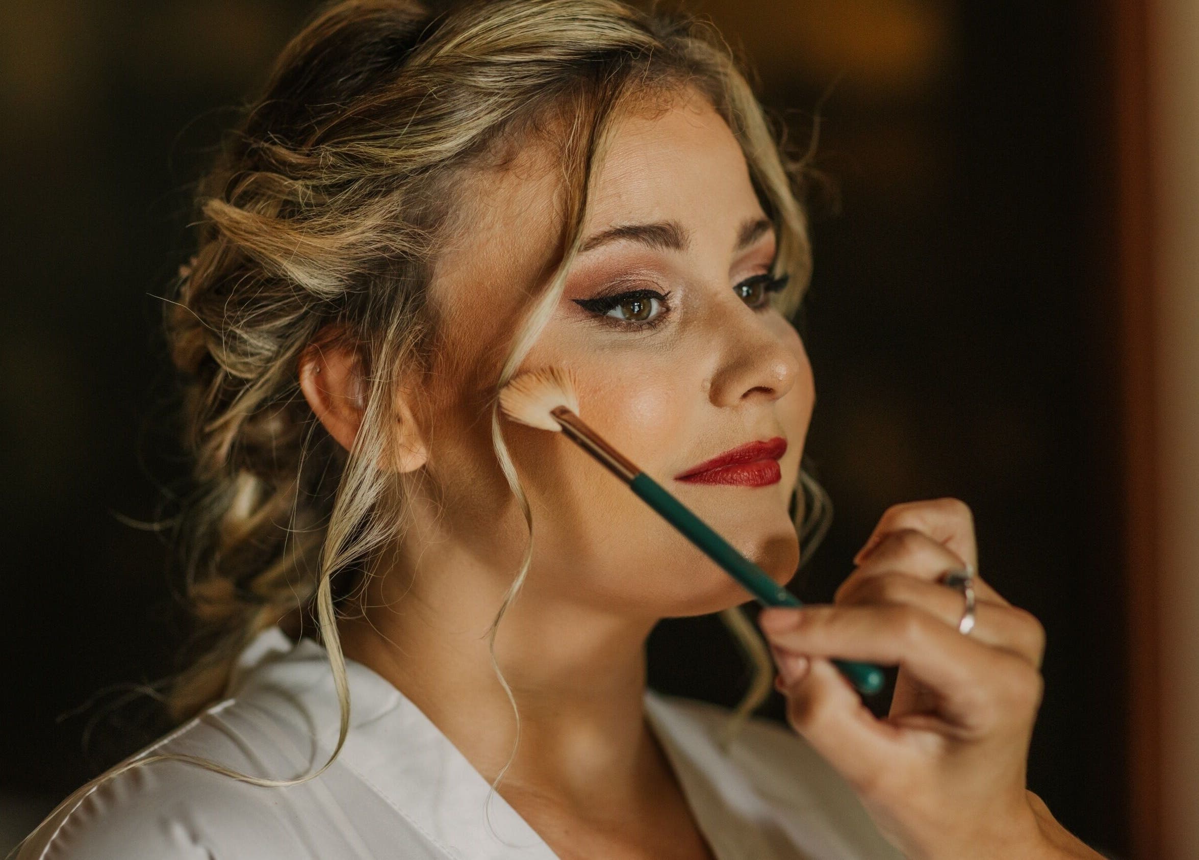 Makeup artist at Angelic Aesthetics in Cape Town, Western Cape, ZA, applying blush to a woman.