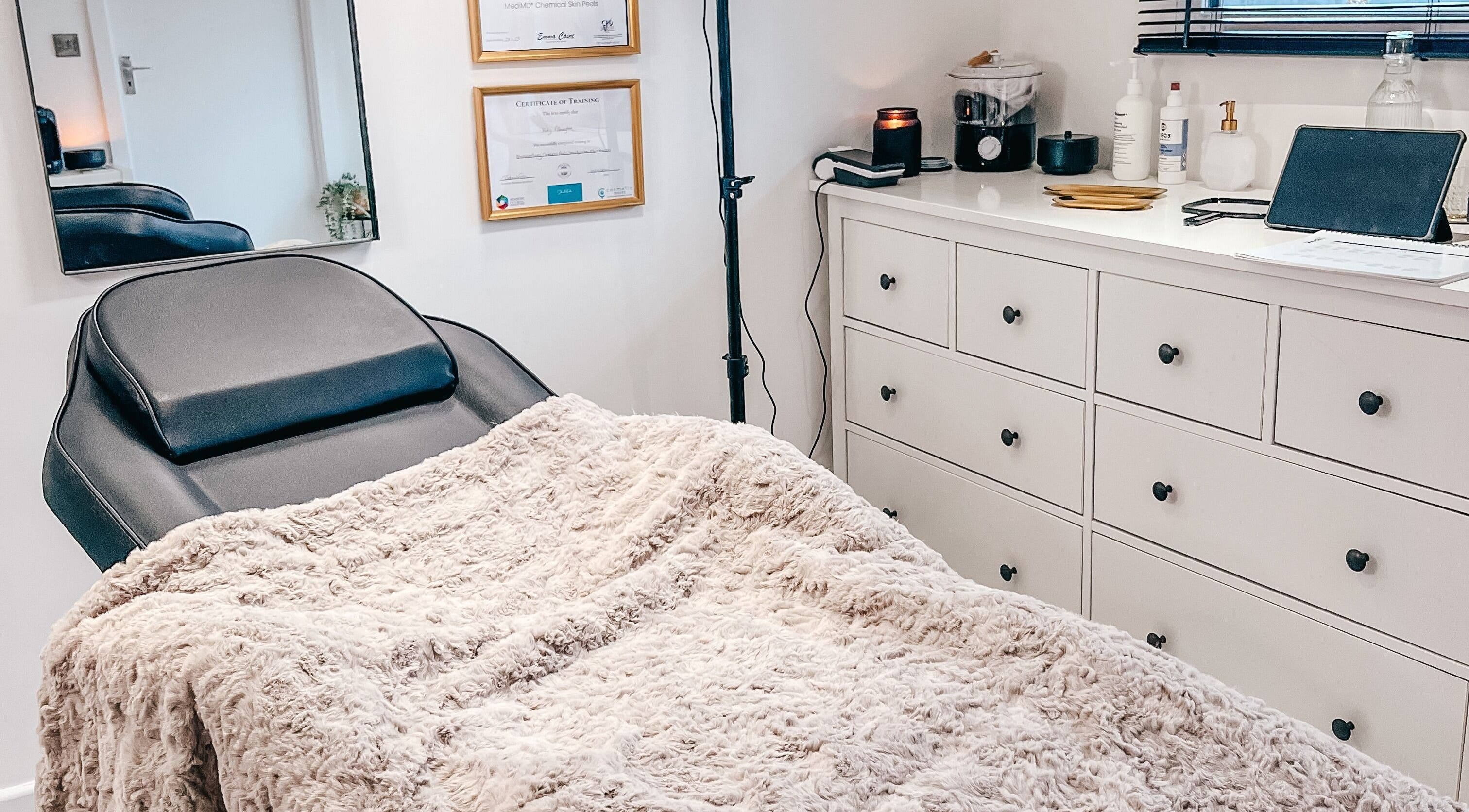 Treatment room at The Cheshire Clinic - Home Clinic, Warrington, England, GB with cozy bed and certificates.