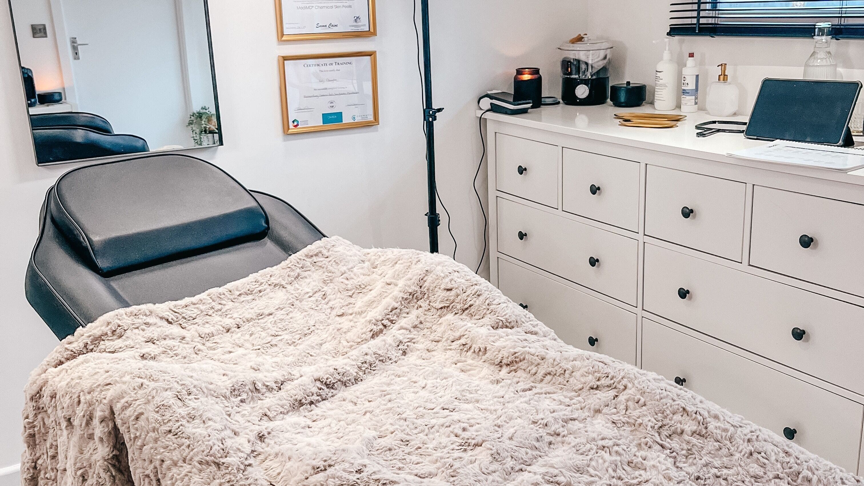 Treatment room at The Cheshire Clinic - Home Clinic, Warrington, England, GB with cozy bed and certificates.