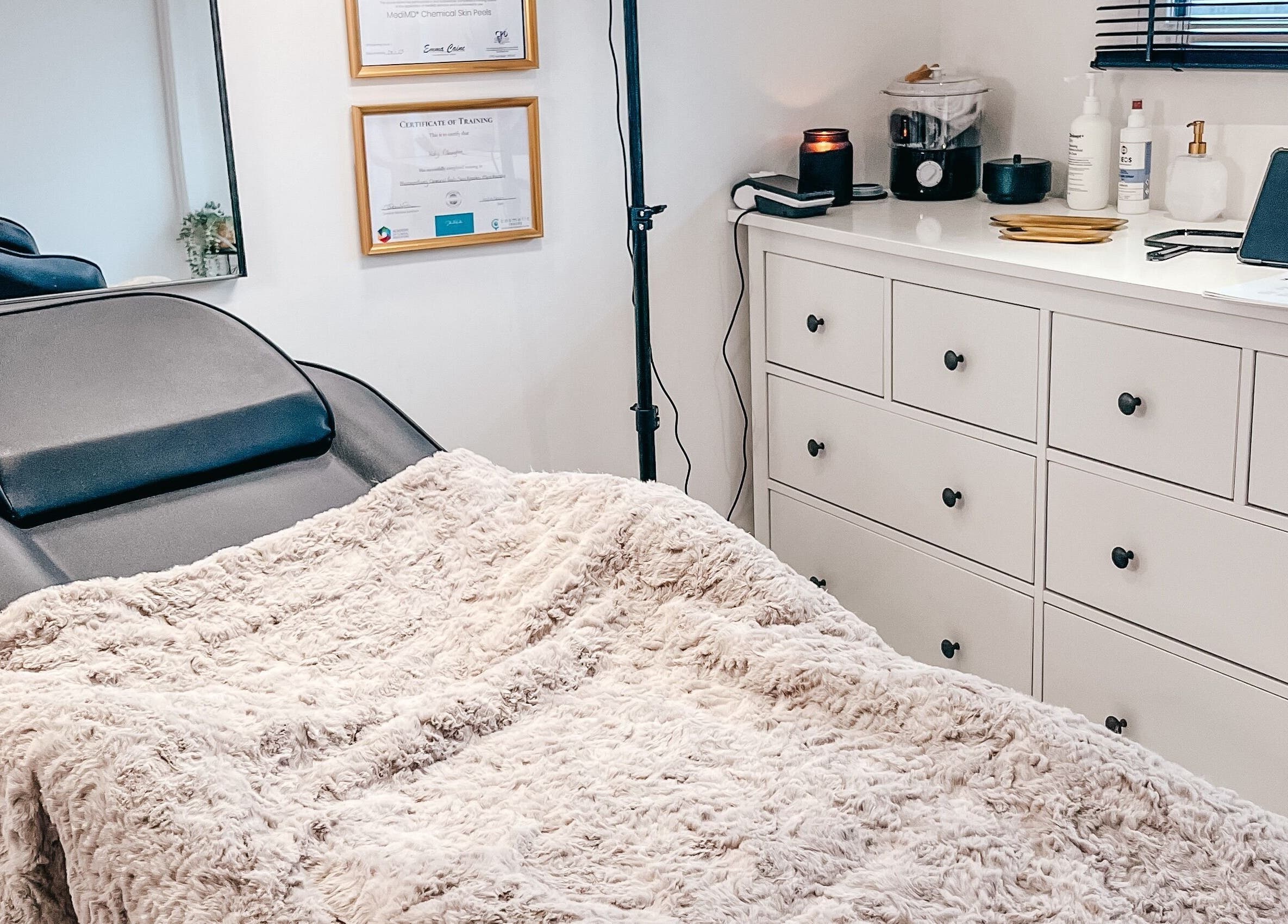 Treatment room at The Cheshire Clinic - Culcheth Clinic, Warrington, England, GB with a plush blanket and framed certificates.