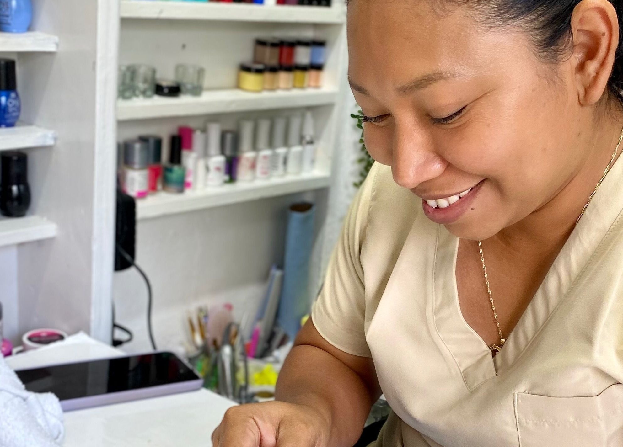 Técnica de belleza en Mamayki, Tulum, Quintana Roo, MX aplicando esmalte con esmero.