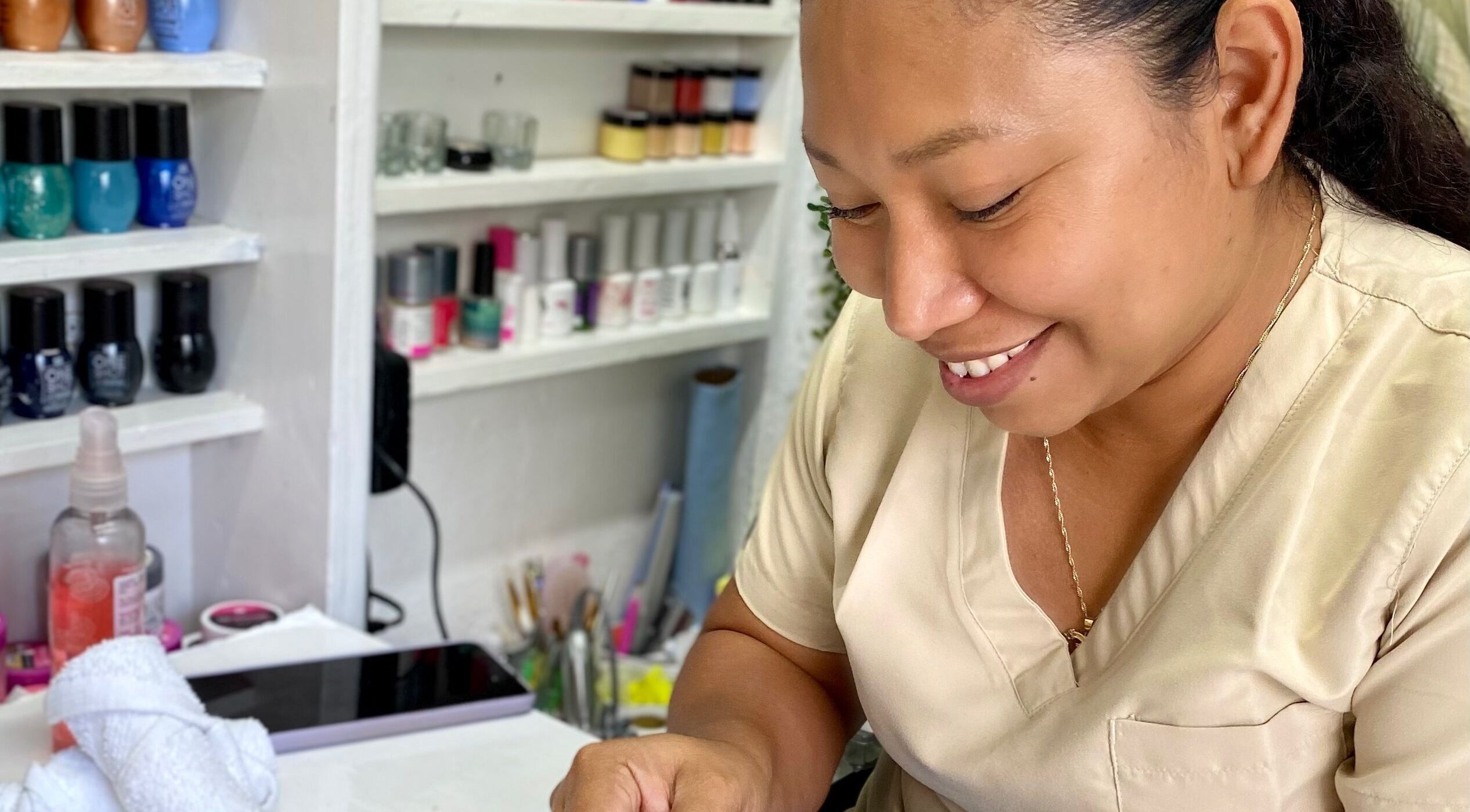 Técnica de belleza en Mamayki, Tulum, Quintana Roo, MX aplicando esmalte con esmero.
