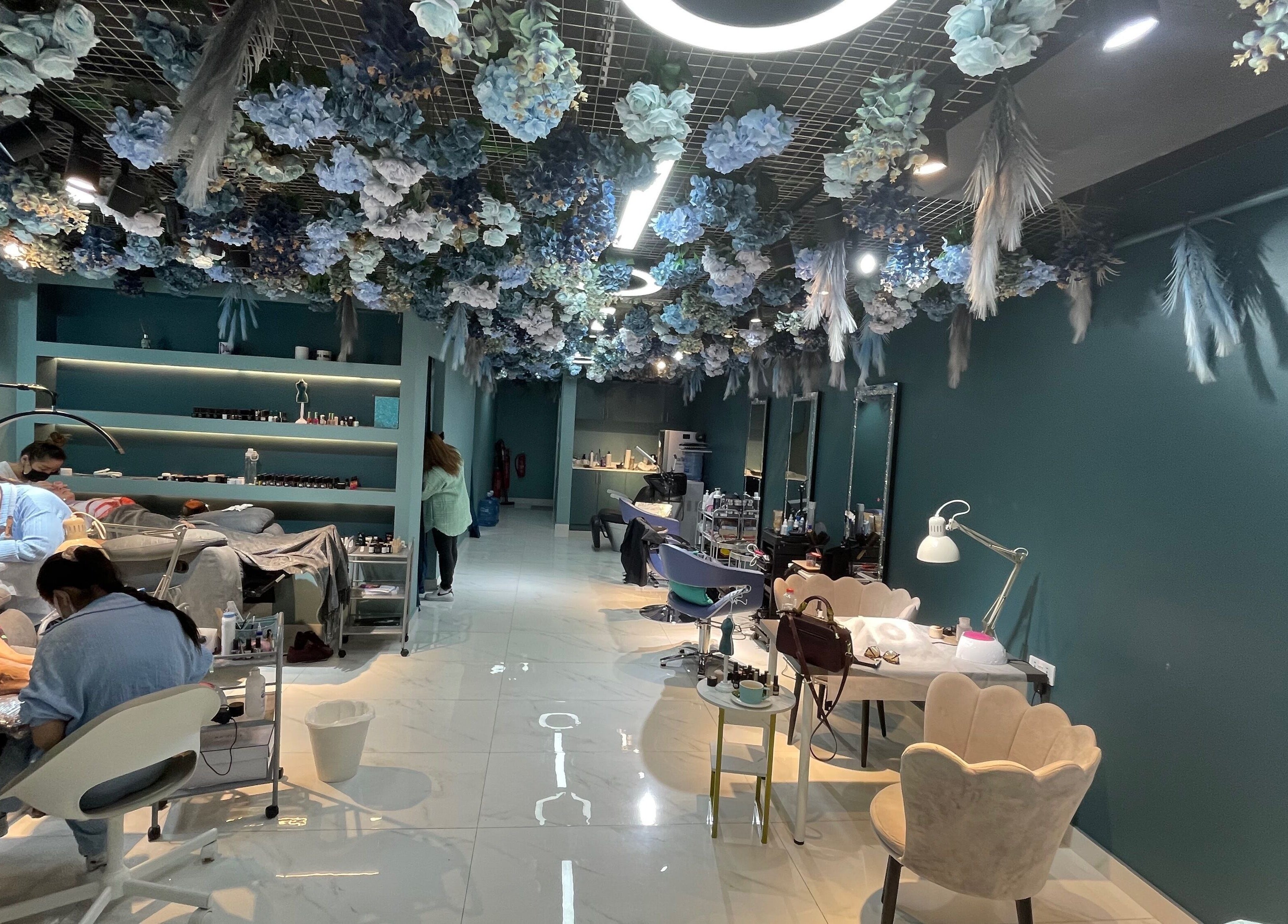 Interior of PAFOS in Dubai, Dubai, AE with floral ceiling decor and beauty service stations.
