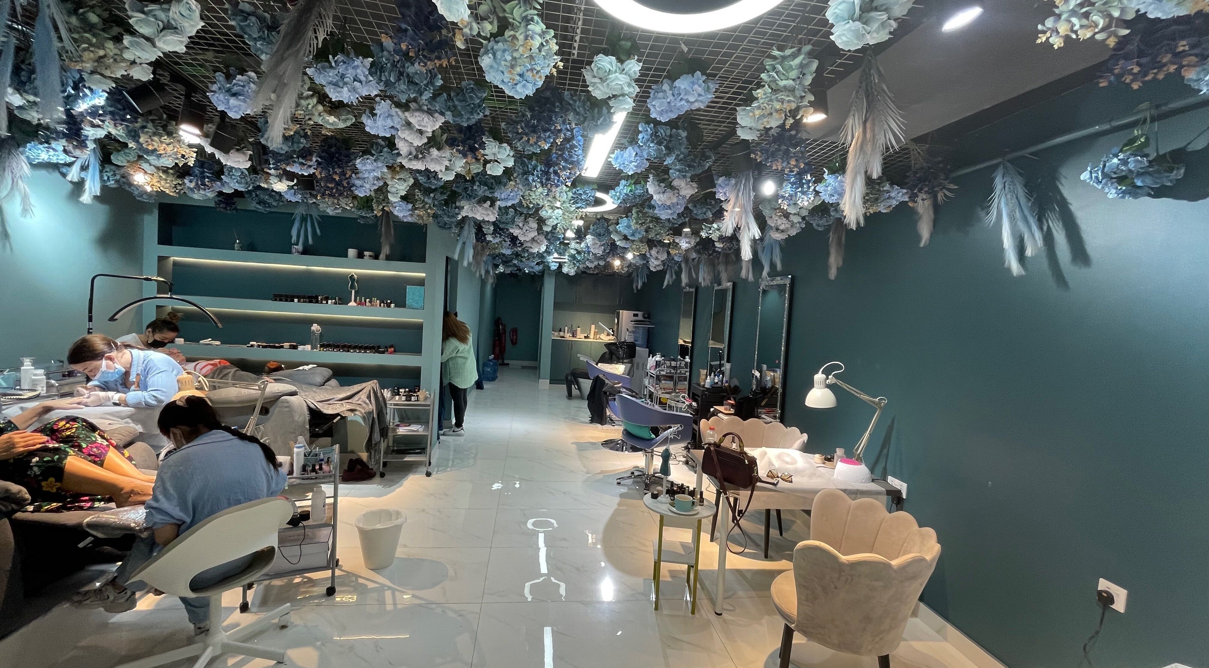 Interior of PAFOS in Dubai, Dubai, AE with floral ceiling decor and beauty service stations.