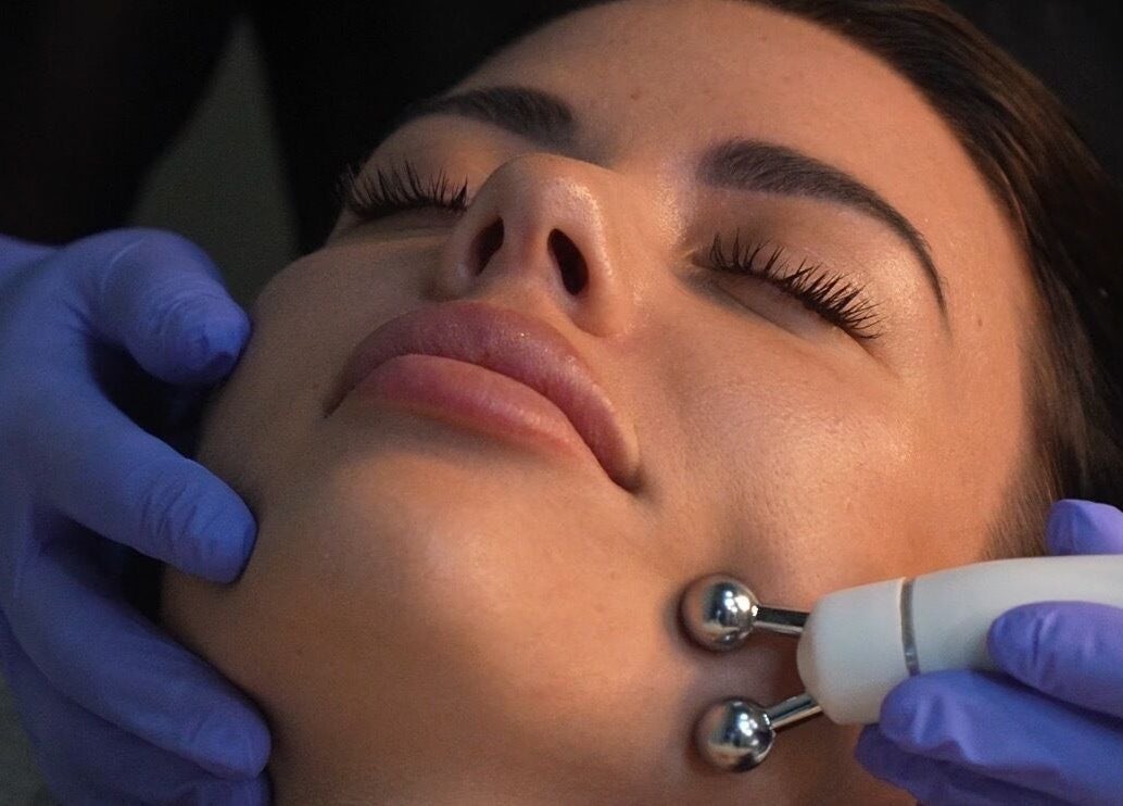 Facial massage treatment at PAFOS, Dubai, Dubai, AE. Gloved hands and device enhance relaxation and skin health.