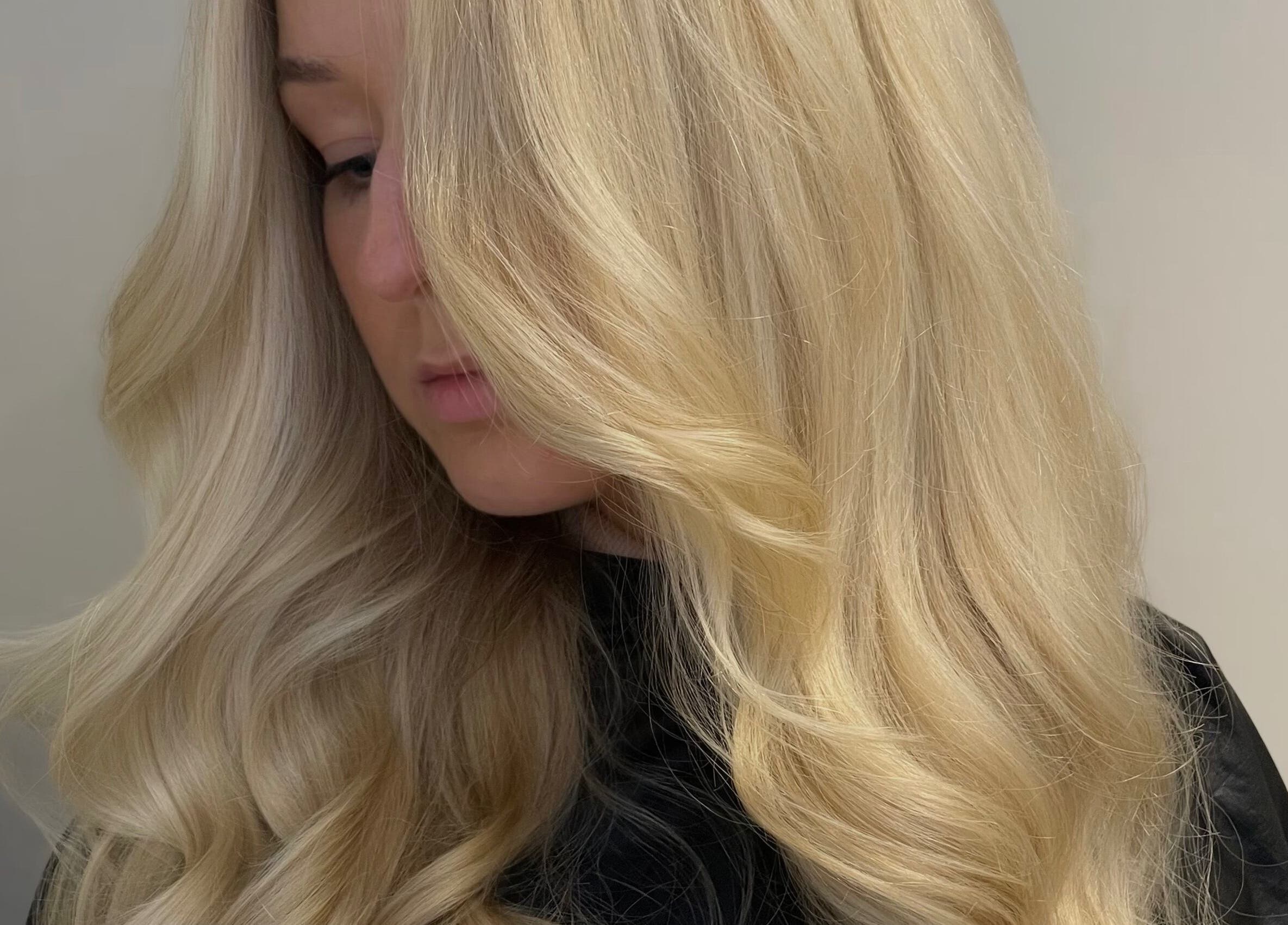 Blonde woman with flowing wavy hair at Hair by LW, Westhill, Scotland, GB.