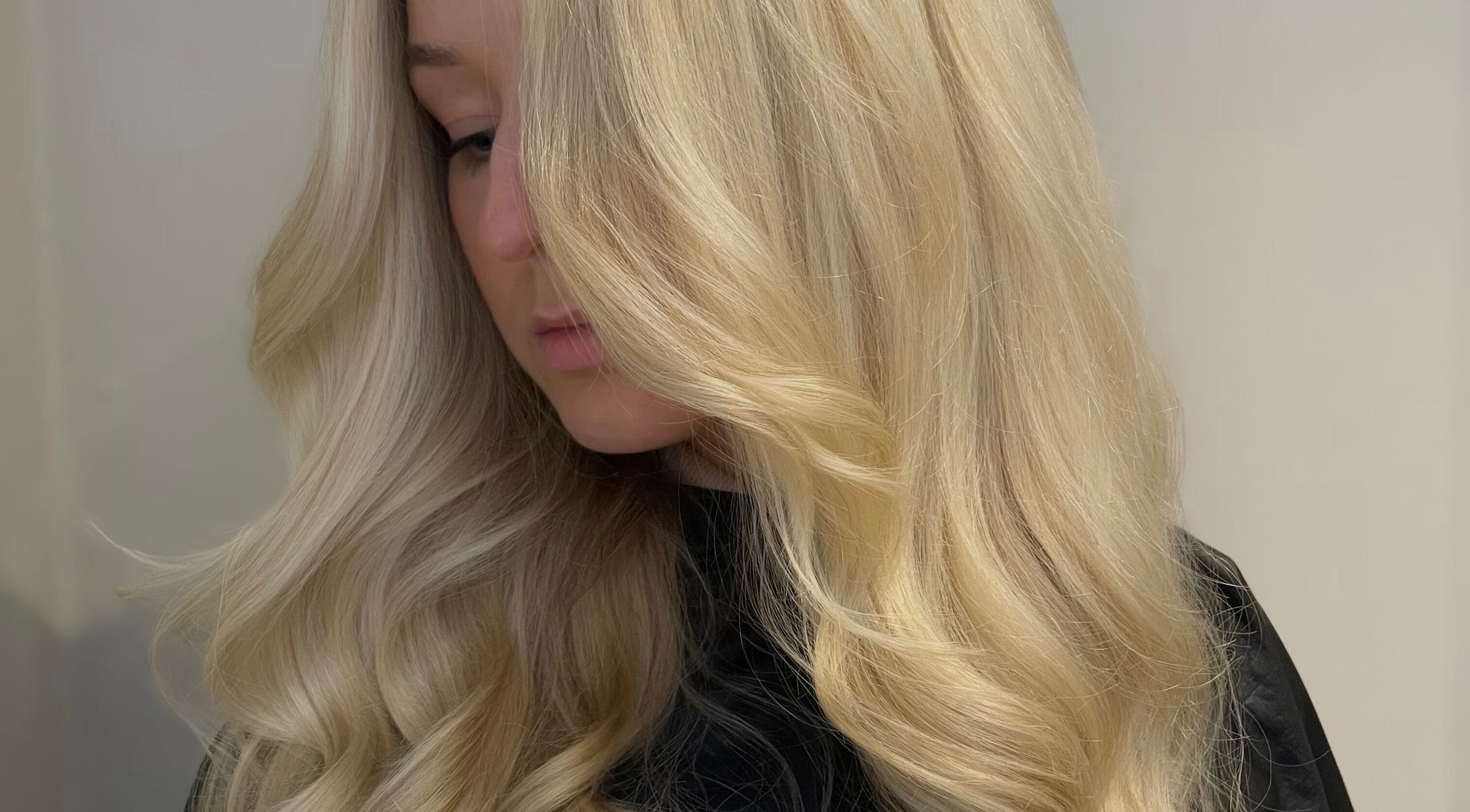 Blonde woman with flowing wavy hair at Hair by LW, Westhill, Scotland, GB.