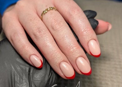 Elegant red-tipped nails by Chloe Hartfield Nail Tech in Burgess Hill, England, GB. Featuring a chic glossy finish.