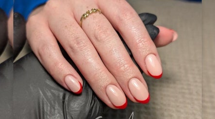 Elegant red-tipped nails by Chloe Hartfield Nail Tech in Burgess Hill, England, GB. Featuring a chic glossy finish.