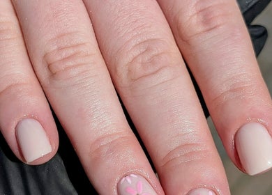 Elegant nude nails with pink flower design at Chloe Hartfield Nail Tech, Burgess Hill, England, GB.