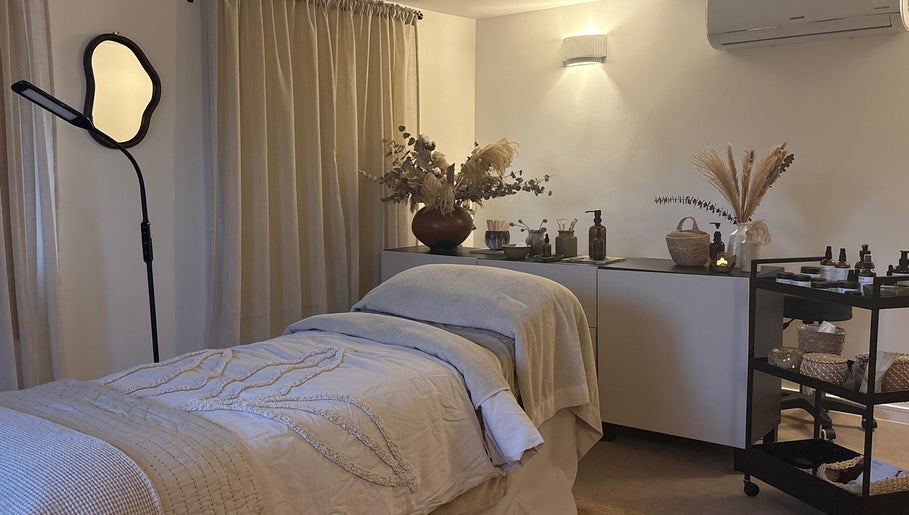 Relaxing treatment room at Mon Remède Beauty, Bristol, England, GB, featuring a cozy massage bed and elegant decor.