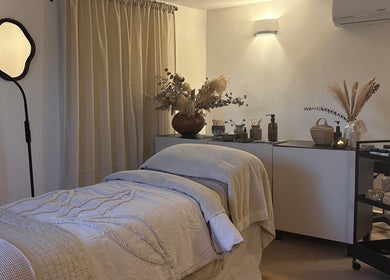 Relaxing treatment room at Mon Remède Beauty, Bristol, England, GB, featuring a cozy massage bed and elegant decor.