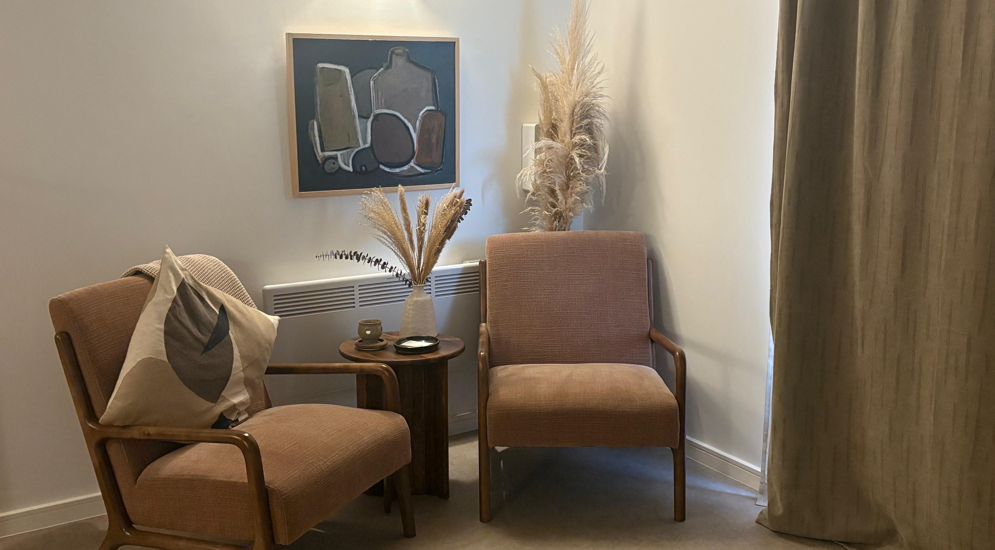 Elegant seating area at Mon Remède Beauty, Bristol, England, GB with beige chairs and artistic decor.