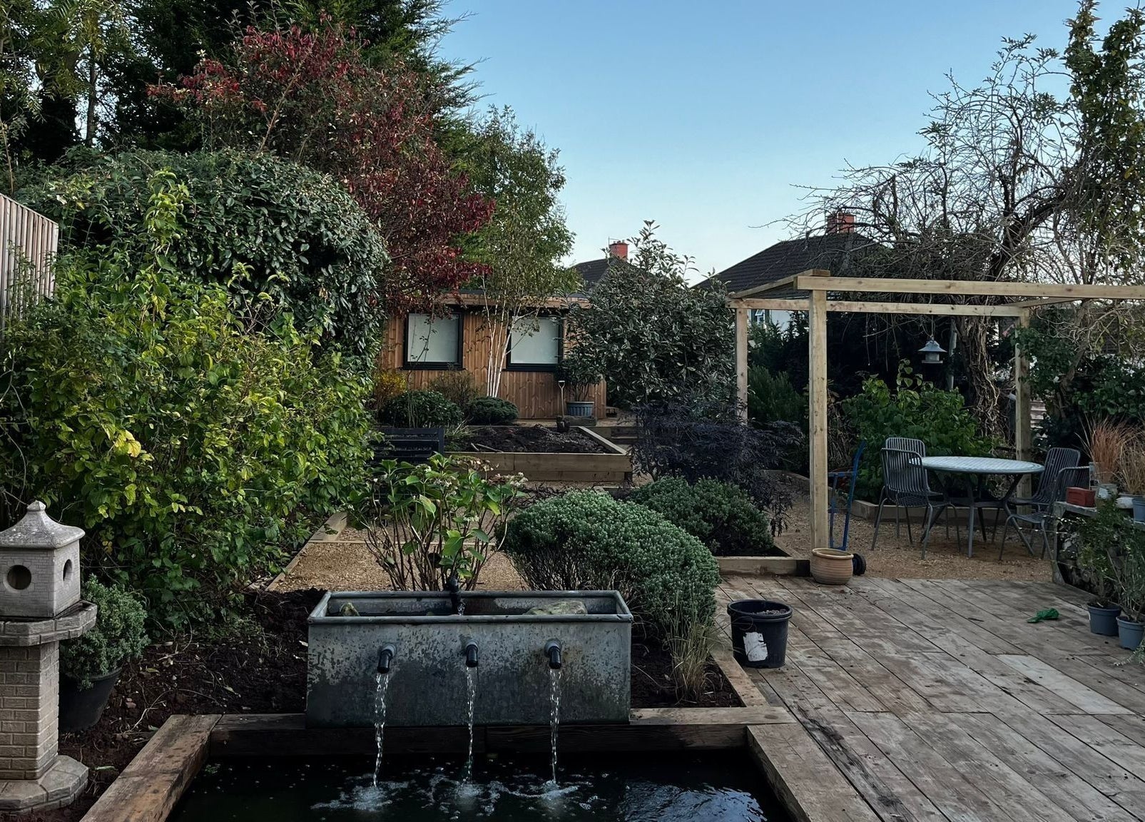 Tranquil garden setting at Mon Remède Beauty in Bristol, England, GB featuring lush greenery and outdoor seating.