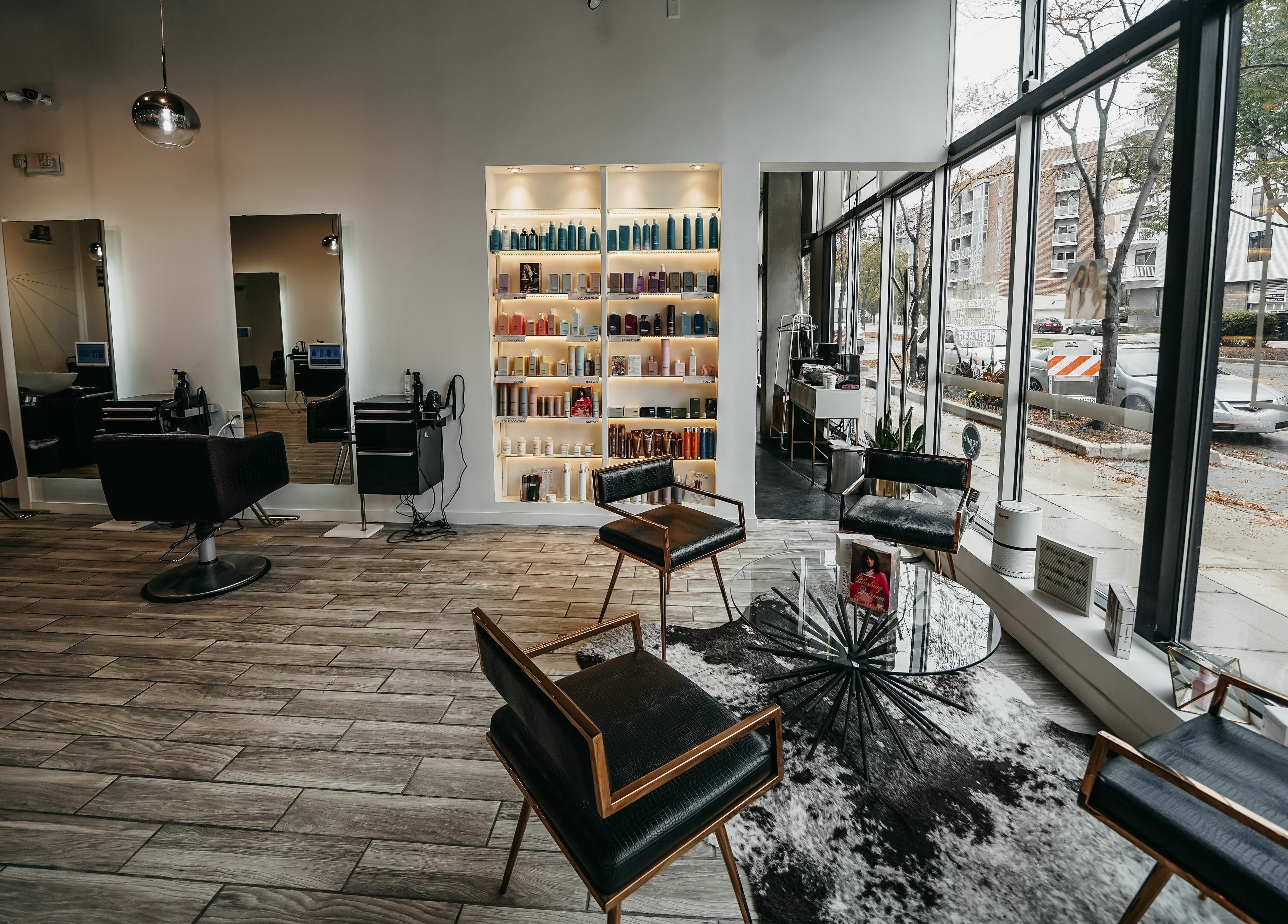 Modern interior of Salon Blānc in Milwaukee, Wisconsin, US, featuring sleek chairs and product shelves.