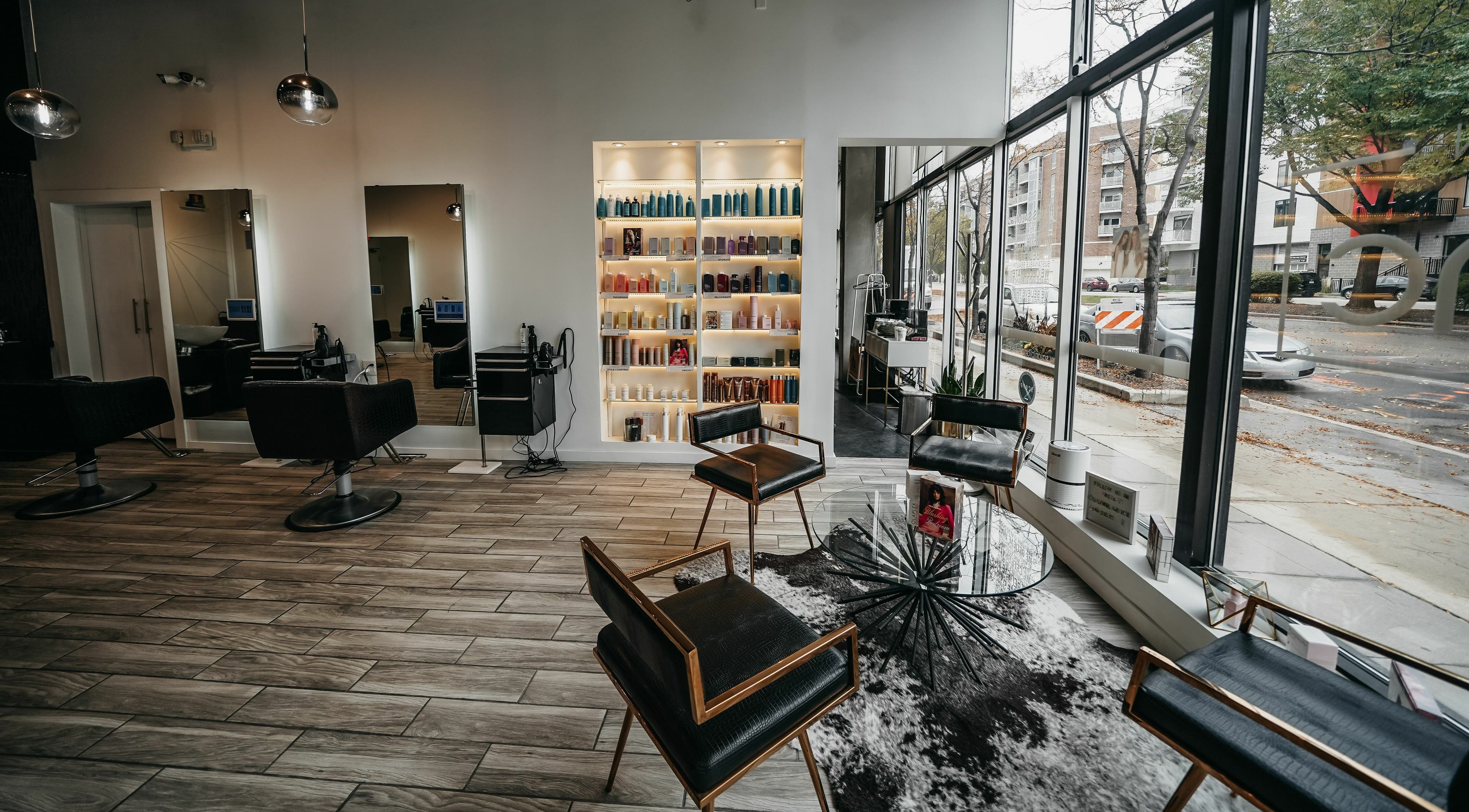 Modern interior of Salon Blānc in Milwaukee, Wisconsin, US, featuring sleek chairs and product shelves.