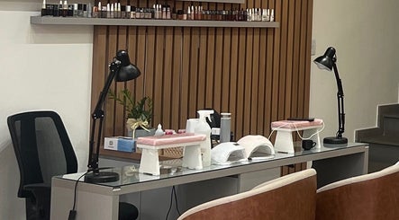 Mesa de manicure no Estúdio Valen, Rio Grande Do Sul, decorada com lâmpadas e produtos de beleza equilibrados.