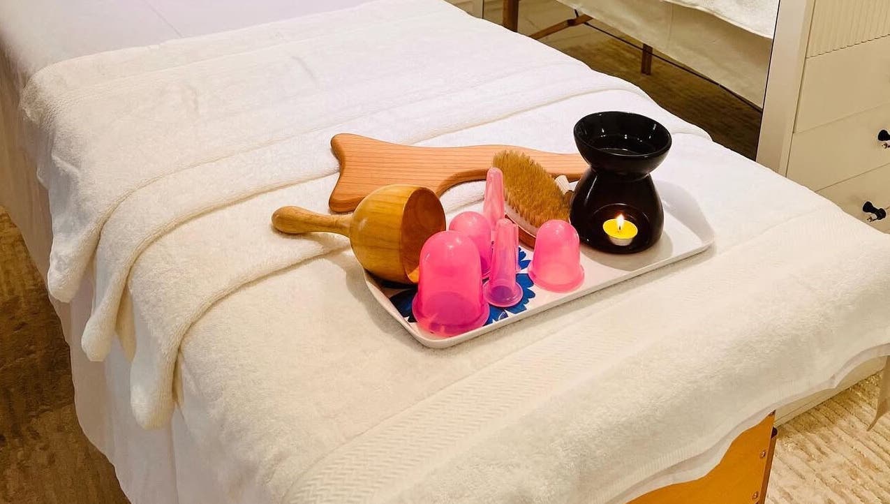 Massage table setup at AESTHE Home Spa and Home Massage, دبي, دبي, AE with relaxing tools and candle.