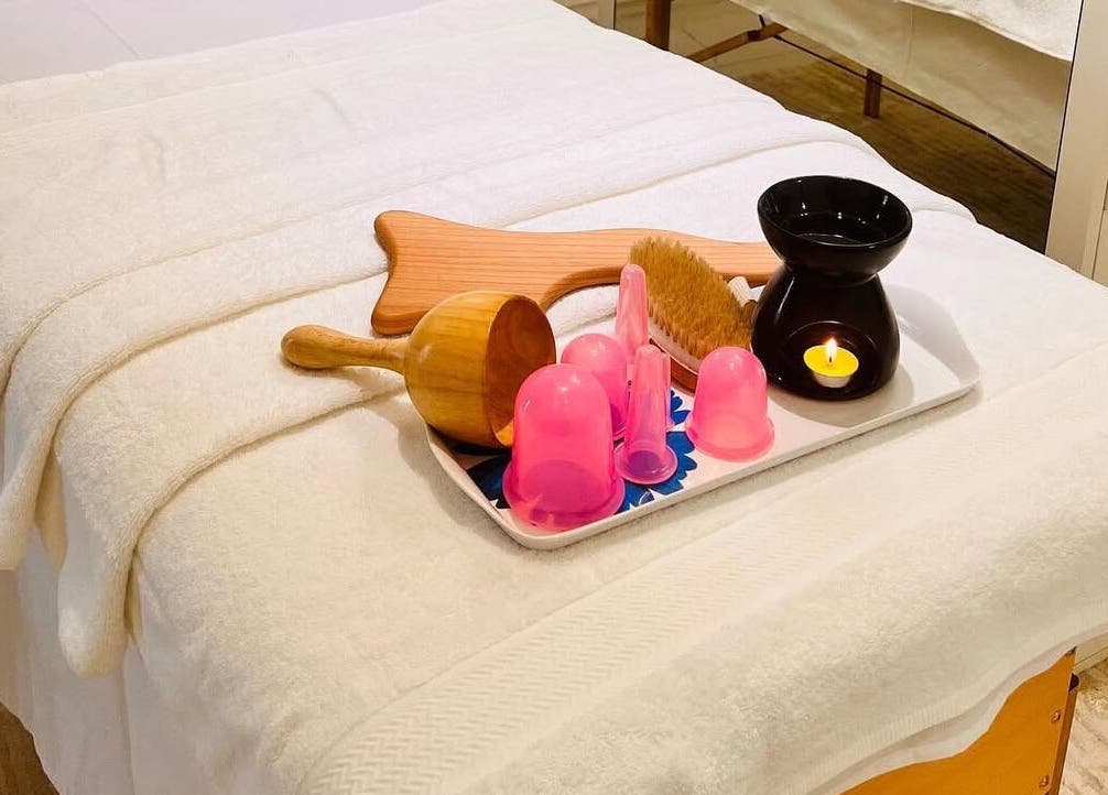 Massage table setup at AESTHE Home Spa and Home Massage, دبي, دبي, AE with relaxing tools and candle.