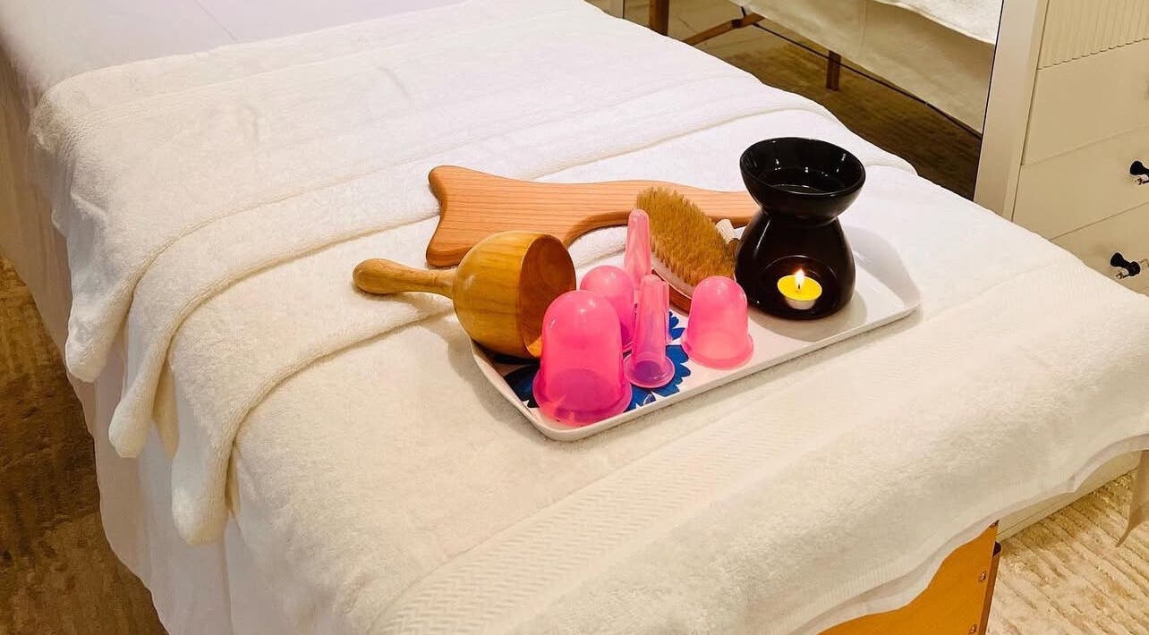 Massage table setup at AESTHE Home Spa and Home Massage, دبي, دبي, AE with relaxing tools and candle.