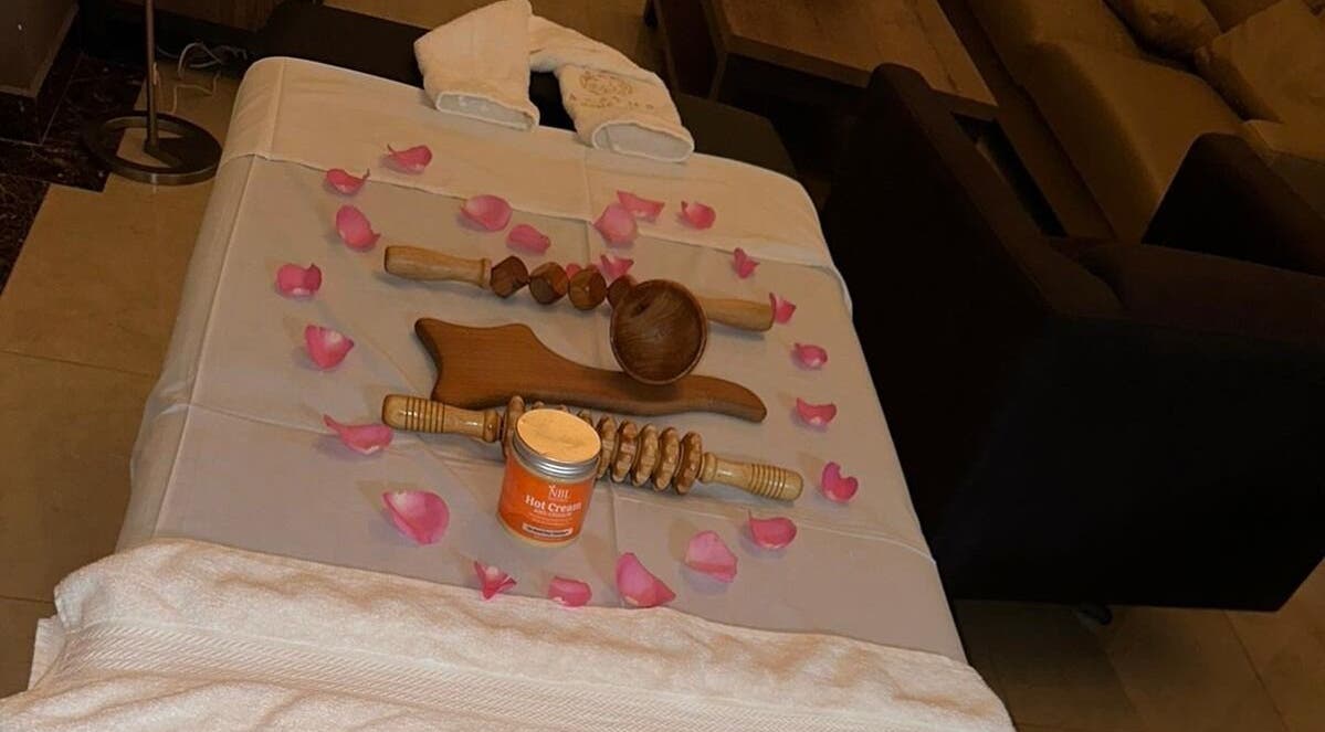 Massage table with wooden tools and petals at Aesthetic Home Spa | Abu Dhabi, Abu Dhabi, AE.