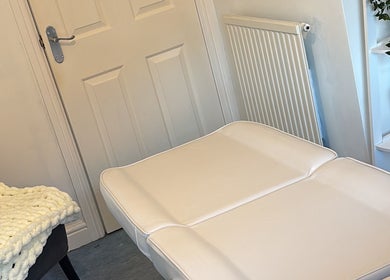 Relaxing treatment room at FernBrowsNW, Old Colwyn, Wales, GB with cozy chair and candle.