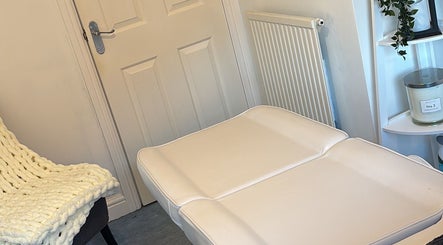 Relaxing treatment room at FernBrowsNW, Old Colwyn, Wales, GB with cozy chair and candle.