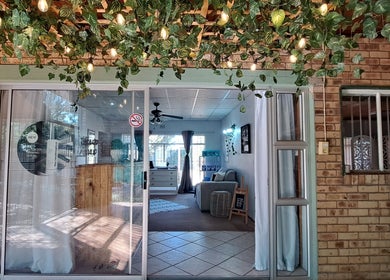 Inviting entrance of Time Out Lia’s Beauty Studio in Orkney, North West, ZA, adorned with greenery and soft lighting.