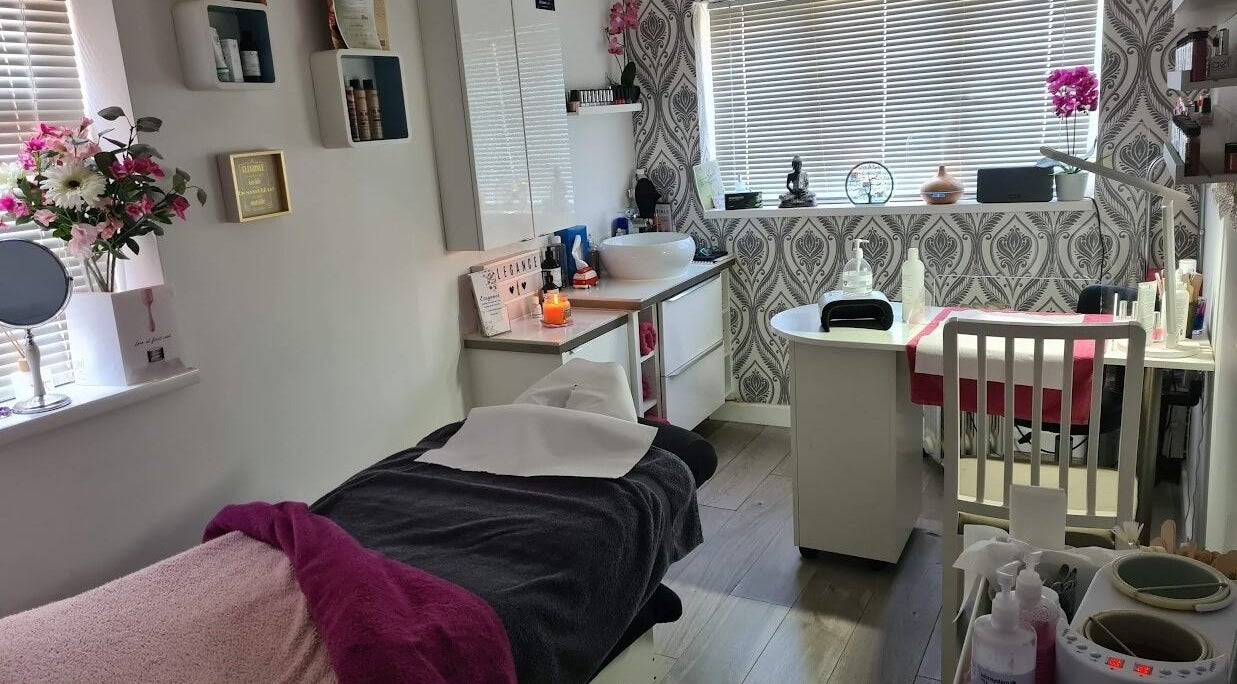 Elegance Beauty treatment room with spa bed, flowers, and decor in Bournemouth, England, GB.