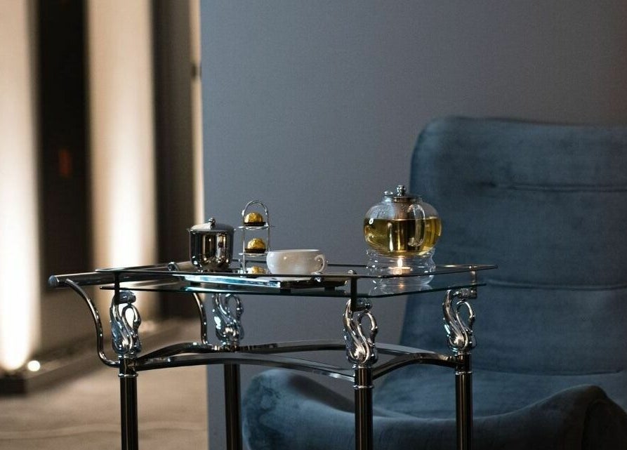 Cozy lounge setup at Prive Spa, دبي, دبي, AE featuring a plush chair and tea service on a sleek table.