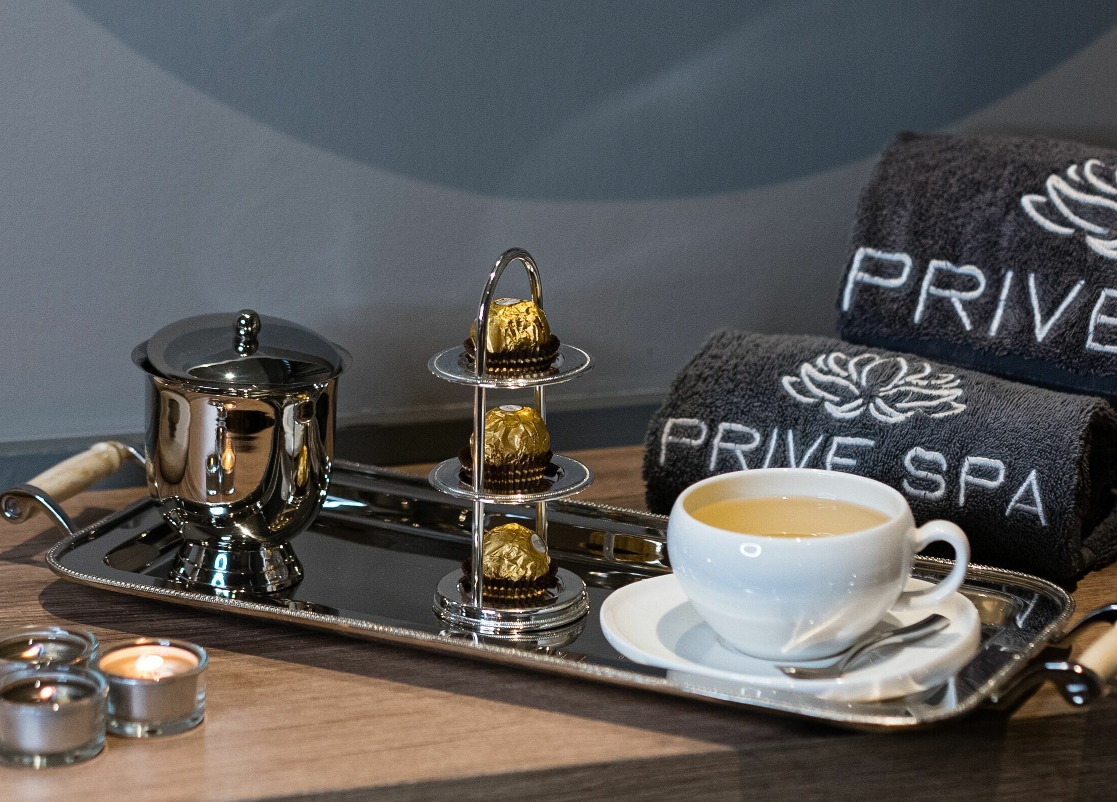 Luxurious service setup at Prive Spa, دبي, دبي, AE with tea, chocolates, and branded towels.