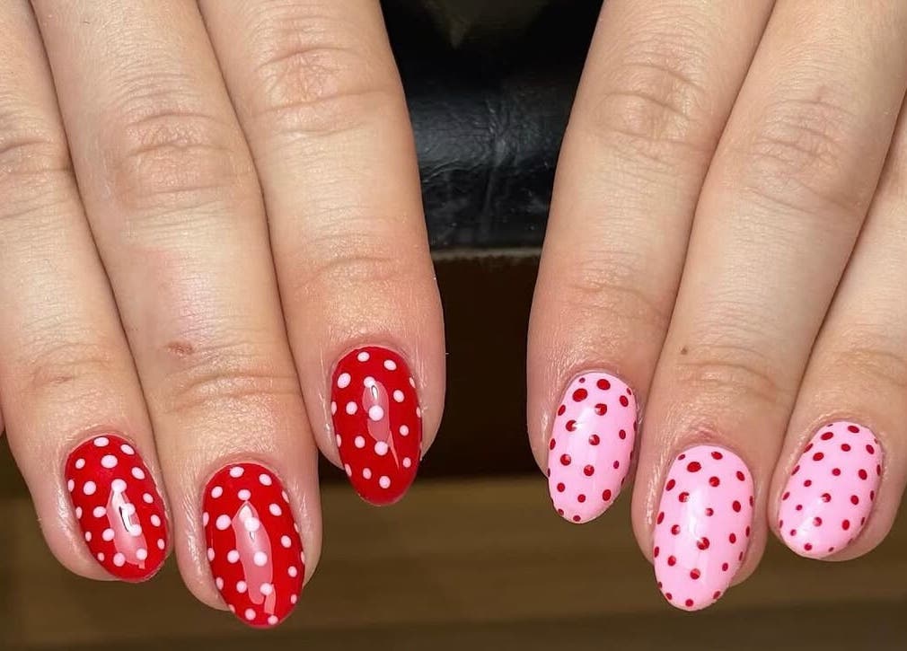 Stylish polka dot nail art at Nails by Ellie, Manchester, England, GB, featuring red and pink designs.