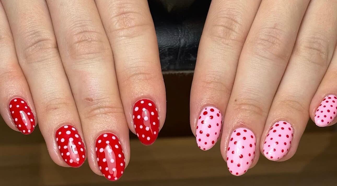 Stylish polka dot nail art at Nails by Ellie, Manchester, England, GB, featuring red and pink designs.