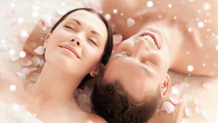 Couple relaxing with rose petals at Relax Spa, Allen, Texas, US. Experience peace and rejuvenation.