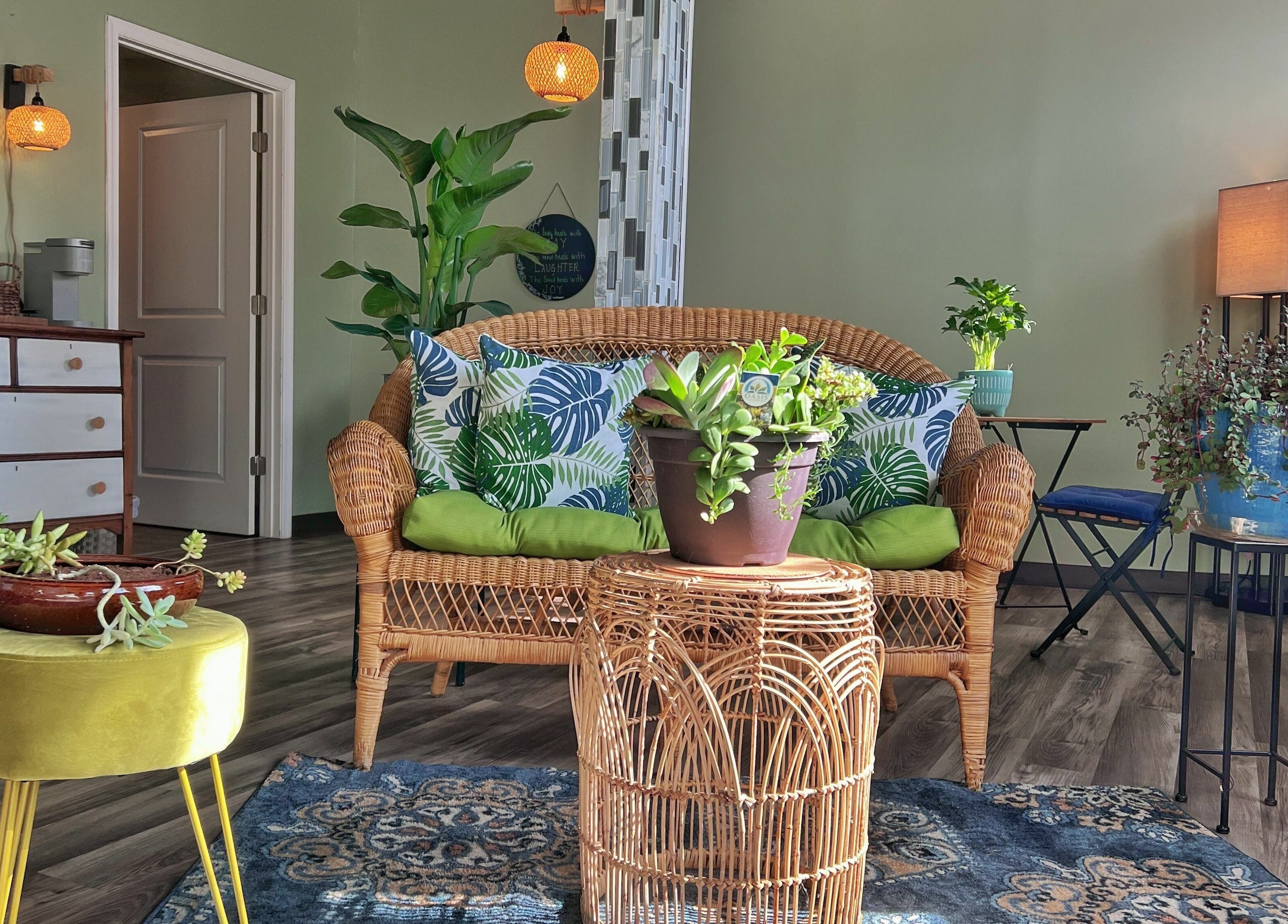 Cozy seating area at Now and Zen Wellness LLC in Throop, Pennsylvania, US with plants and wicker furniture.