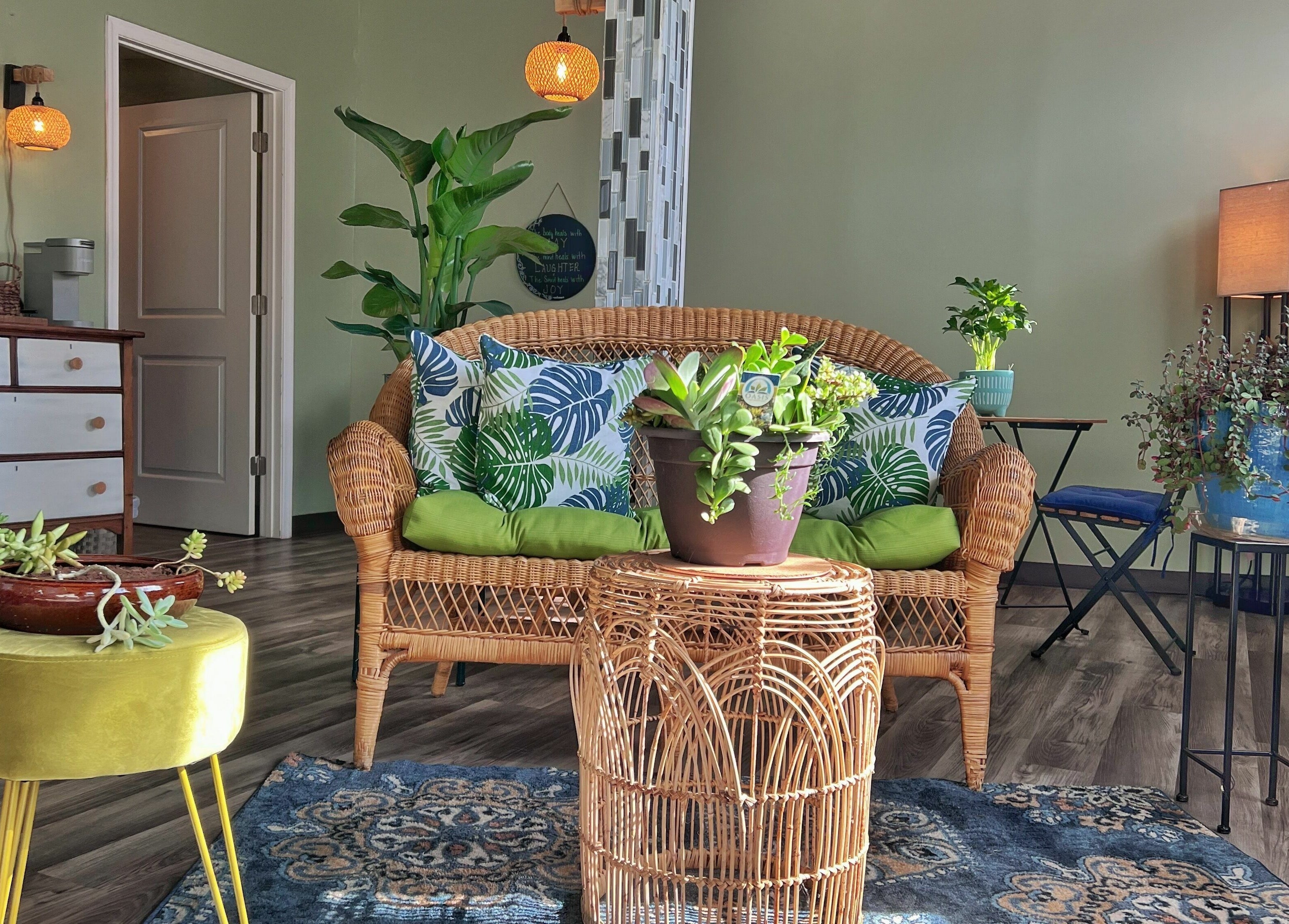 Cozy seating area at Now and Zen Wellness LLC in Throop, Pennsylvania, US with plants and wicker furniture.